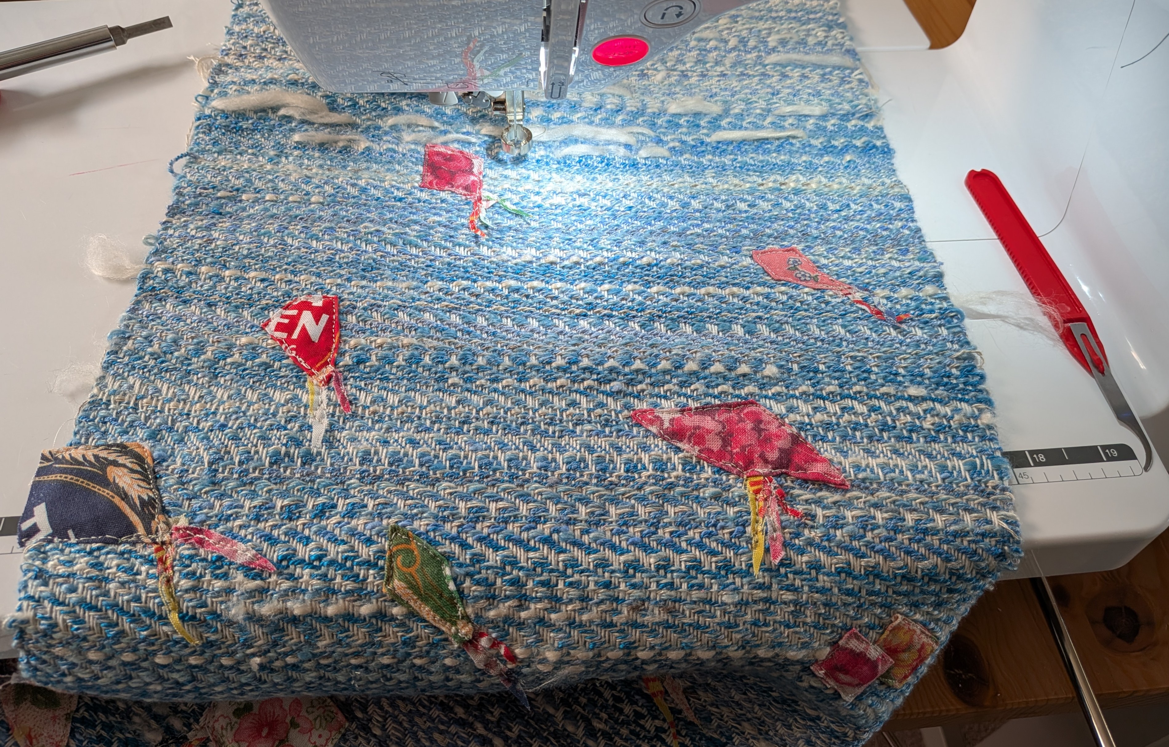 blue background with applique kites on a sewing machine bed